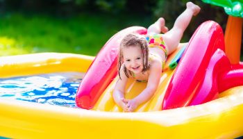 Niña tirándose por el tobogán de un centro de juego INTEX