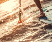 Practicando paddle surf al atardecer